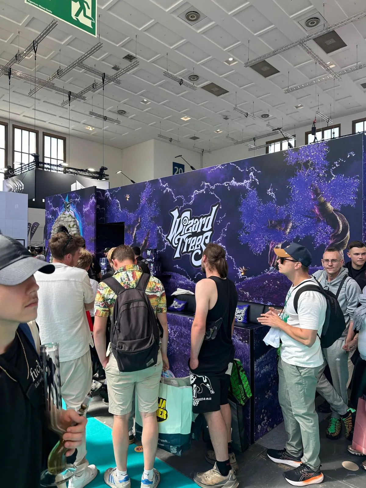 Stand Wizard Trees avec branding violet et visiteurs à Mary Jane Berlin 2026